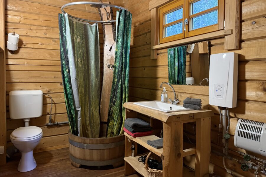 Einzigartig ist auch das Badezimmer im Blockhaus, bei dem die Dusche einen aus Holz gefertigten Zuber als Untergrund hat | Blockhütten Schwarzwald